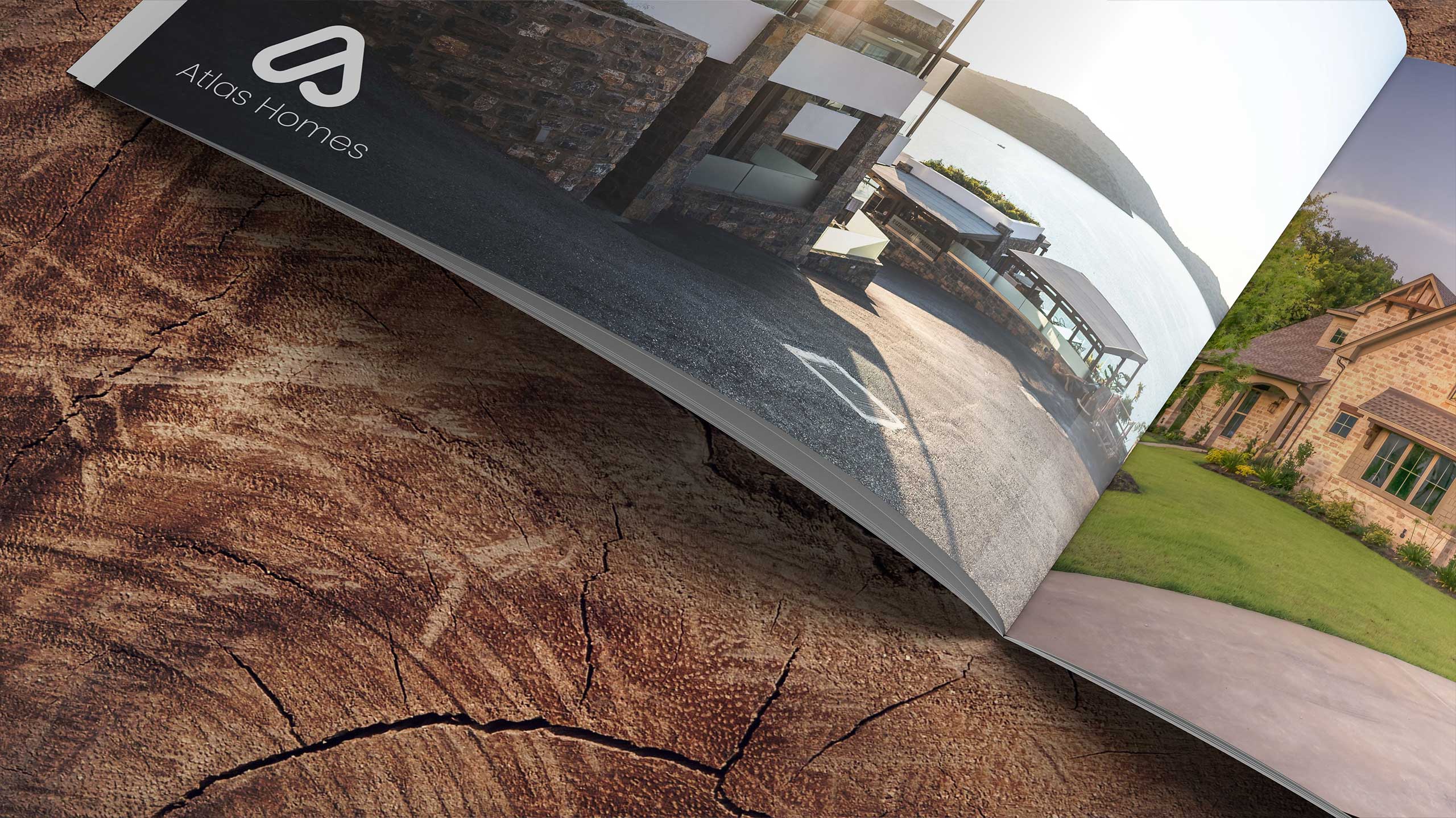 Atlas Homes brochure featuring modern property visuals, logo, and high-quality design elements on a textured wooden background.